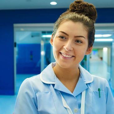 Smiling young nurse in hospital lobby